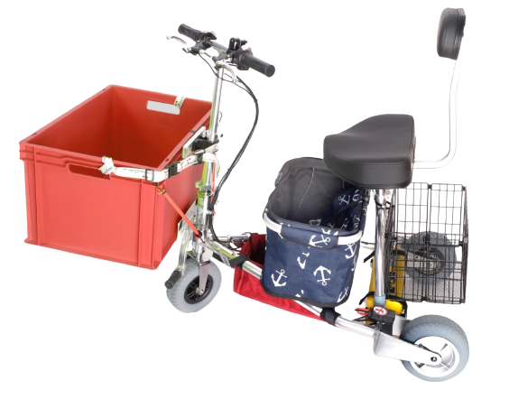 TravelScoot con un cajón rojo en la parte delantera, una cesta de transporte plegable en el centro y una cesta plegable en la parte trasera. El cajón rojo se fijó con el kit Smart Lagguage